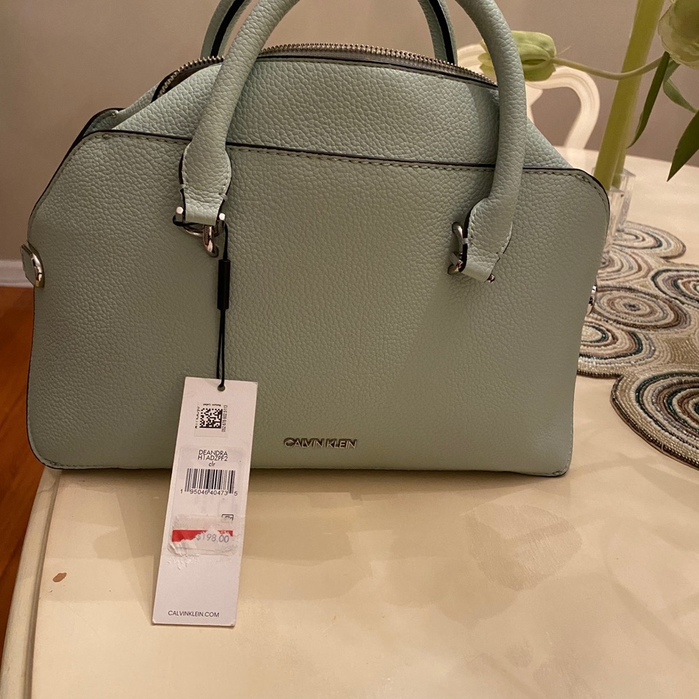 Womens bag, new, sea foam green color with shoulder strap and storage bag.